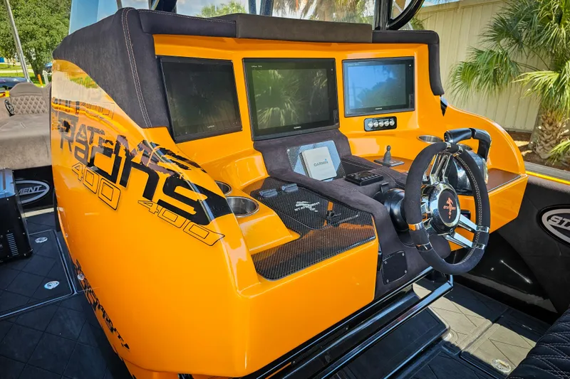 Slide: The Image of Orange 2016 Statement 380 Open boat dashboard with multiple screens and steering wheel. - 17