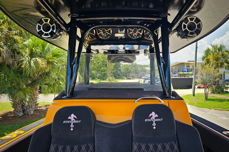 Slide: The Image of 2016 Statement 380 Open boat interior with speakers and branded seats, surrounded by palm trees. - 23