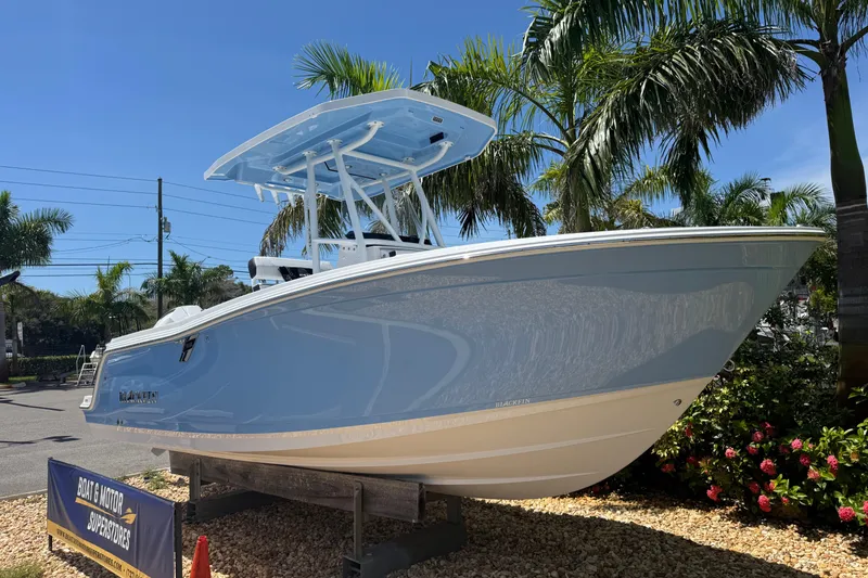Slide: The Image of 2026 Blackfin 222 CC boat displayed outdoors with palm trees and clear sky. - 10