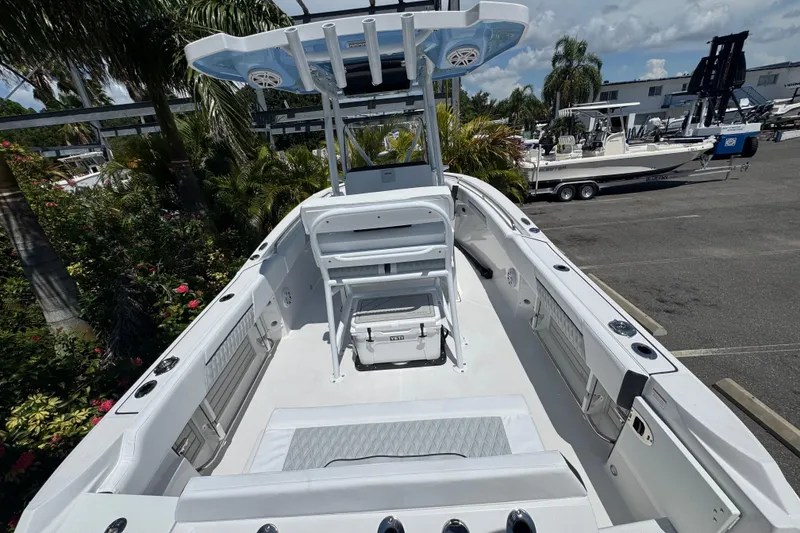 Slide: The Image of 2026 Blackfin 222 CC boat interior with seating and storage, surrounded by lush greenery. - 12