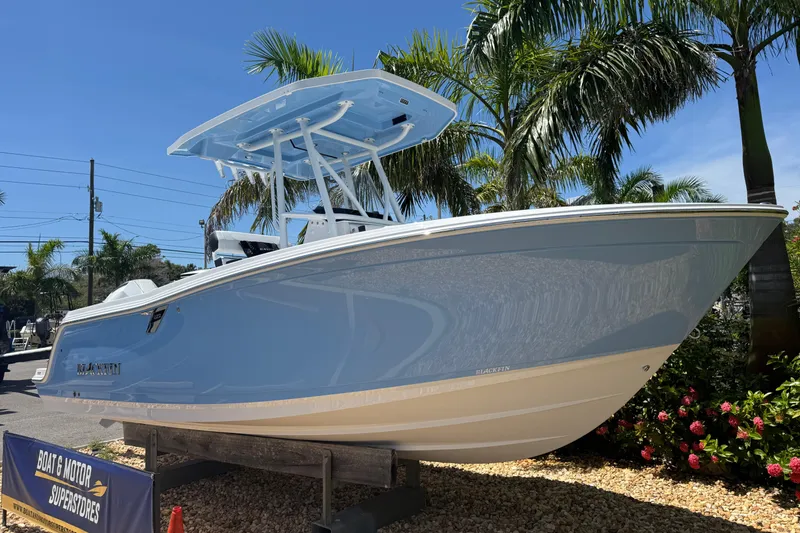 Slide: The Image of 2026 Blackfin 222 CC boat displayed outdoors with palm trees in the background. - 2