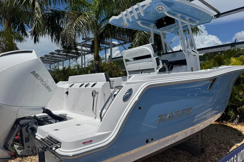 Slide: The Image of 2026 Blackfin 222 CC boat with Mercury engine, displayed outdoors under palm trees. - 3