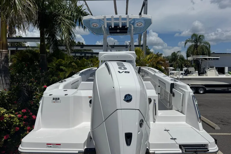 Slide: The Image of 2026 Blackfin 222 CC boat with powerful V8 engine, docked amidst tropical greenery. - 5