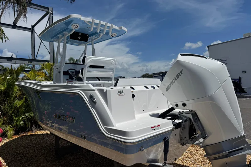 Slide: The Image of 2026 Blackfin 222 CC boat with Mercury engine, docked outdoors under clear sky. - 6