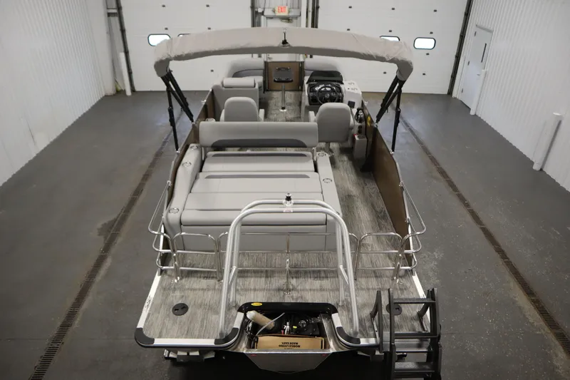 Slide: The Image of 2026 Bentley Pontoons Legacy 223 Swingback Tri-toon in a garage, showcasing spacious seating and modern design. - 9