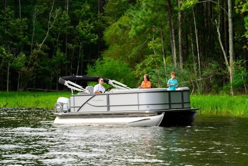 Slide: The Image of 2026 Bentley Pontoons LE 200 CW cruising on a serene lake with lush forest backdrop. - 36