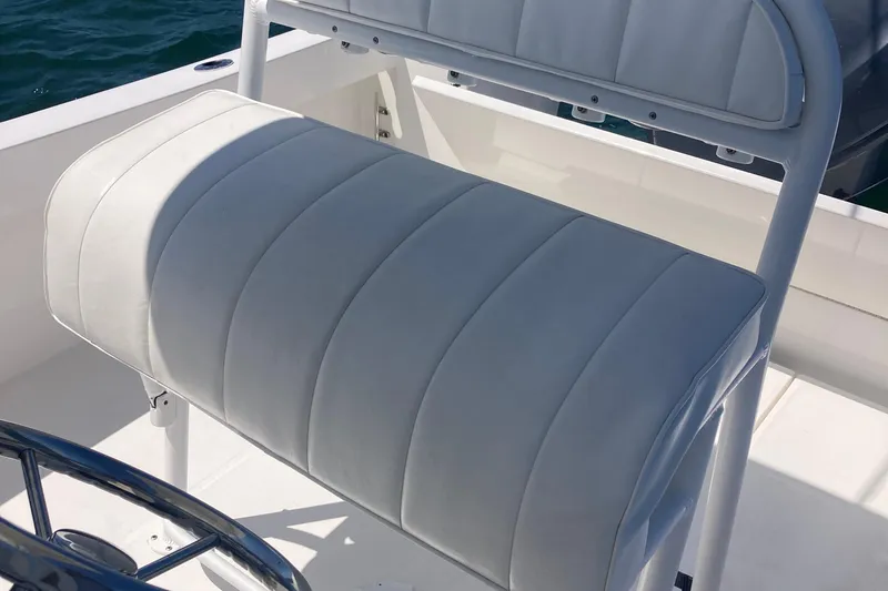 Slide: The Image of 2015 Regulator 23 Forward Seating boat with white cushioned seat and steering wheel. - 10