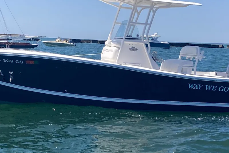 Slide: The Image of 2015 Regulator 23 Forward Seating boat on water, featuring sleek design and spacious seating. - 2