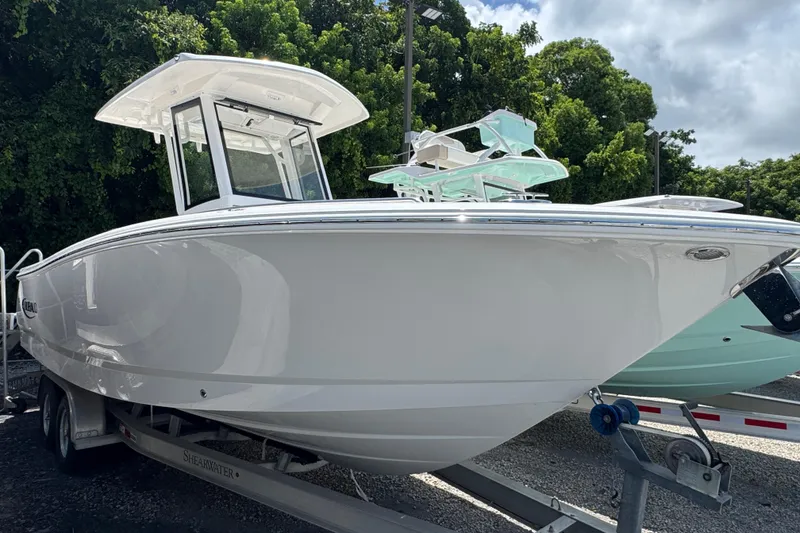 The Image of 2025 Robalo R250 Center Console boat on trailer, surrounded by trees. - 1
