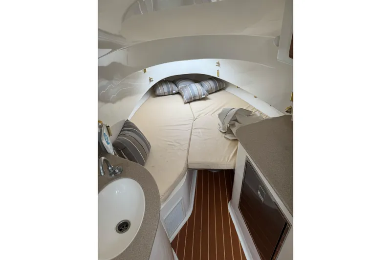 Slide: The Image of 2008 Contender 36 Fisharound cabin interior with bed, sink, and striped pillows. - 10