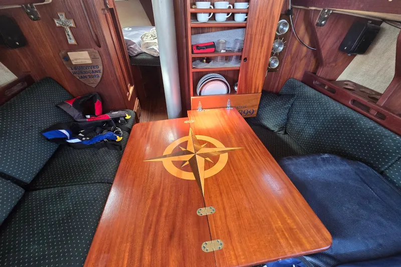 Slide: The Image of Interior of a 1981 Morgan 321 sailboat with wooden table and cozy seating. - 10