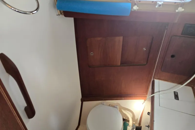 Slide: The Image of 1981 Morgan 321 yacht bathroom interior with wooden paneling and compact toilet. - 5