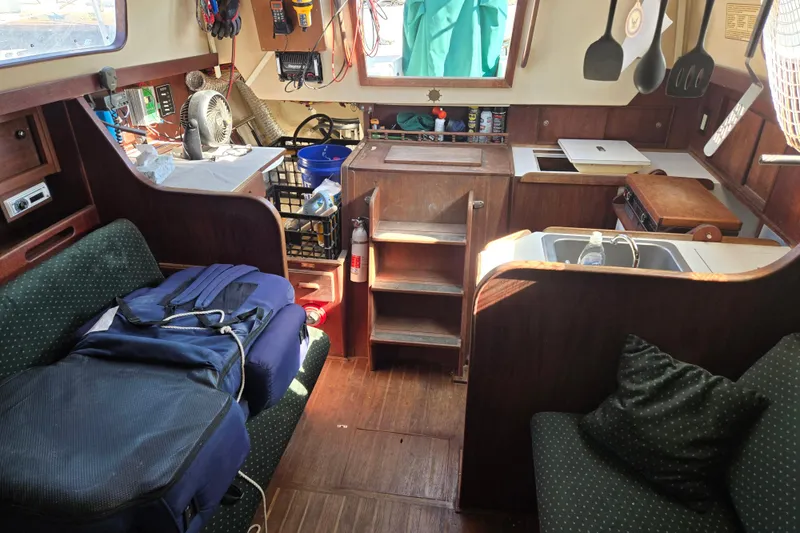 Slide: The Image of Interior of a 1981 Morgan 321 sailboat with cozy seating and compact kitchen area. - 6
