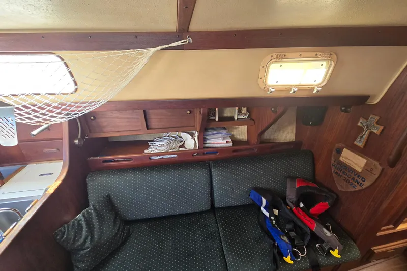 Slide: The Image of Interior of a 1981 Morgan 321 sailboat with seating, storage, and life jackets. - 7