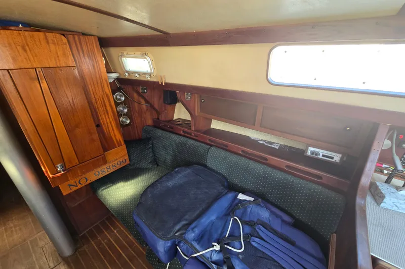 Slide: The Image of Interior of 1981 Morgan 321 sailboat with wooden cabinetry and cushioned seating. - 9