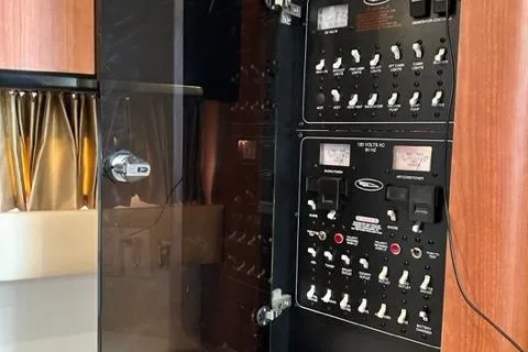 Slide: The Image of Control panel inside a 2004 Chaparral Signature 350 boat, featuring switches and meters. - 17