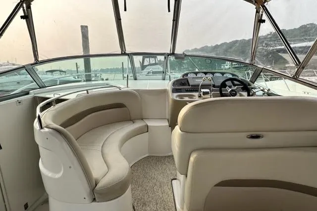 Slide: The Image of 2004 Chaparral Signature 350 boat interior with beige seating and helm, overlooking marina. - 5