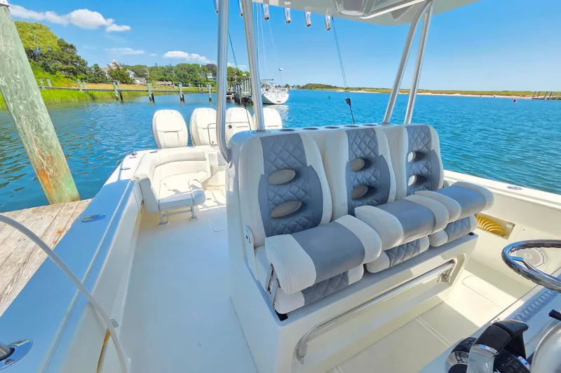 Slide: The Image of 2016 SeaVee 390Z boat interior with luxurious seating, docked by a scenic waterfront. - 4