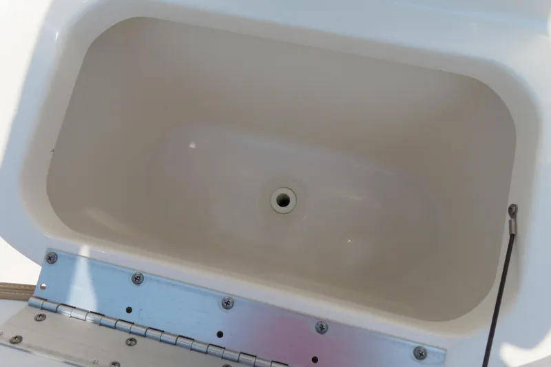 Slide: The Image of Livewell compartment in a 2017 Key West 203 FS boat, featuring a drain plug. - 18
