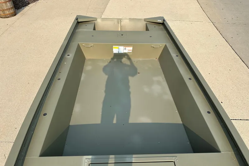 Slide: The Image of 2026 Tracker Grizzly 1754 Utility boat interior, empty and parked on concrete surface. - 4