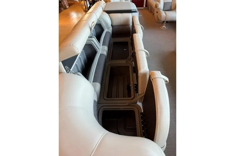 Slide: The Image of 2025 Sun Tracker Party Barge 24 DLX interior seating with open storage compartments. - 6