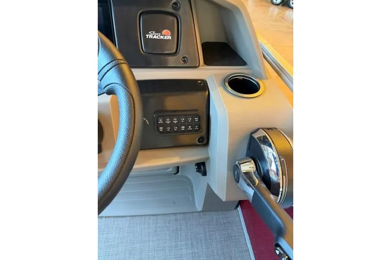 Slide: The Image of 2025 Sun Tracker Party Barge 24 DLX helm with steering wheel and control panel. - 14