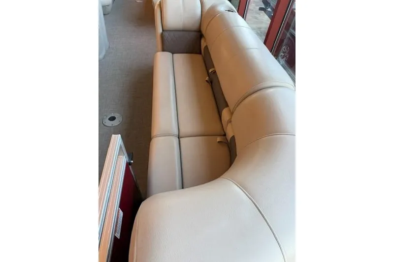 Slide: The Image of 2025 Sun Tracker Party Barge 24 DLX interior with beige seating and carpeted floor. - 7