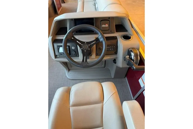 Slide: The Image of 2025 Sun Tracker Party Barge 24 DLX helm with steering wheel and controls. - 12