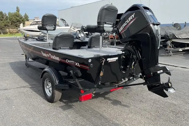 Slide: The Image of 2026 Tracker Bass Tracker Classic XL boat with Mercury engine, parked on a trailer. - 5