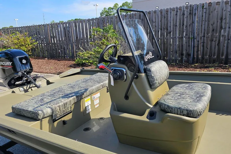 Slide: The Image of 2026 Tracker Grizzly 1860 CC boat with camouflage seating and Mercury outboard motor. - 7