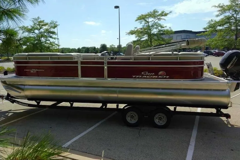 Slide: The Image of 2025 Sun Tracker Party Barge 24 DLX pontoon boat on trailer in parking lot. - 6