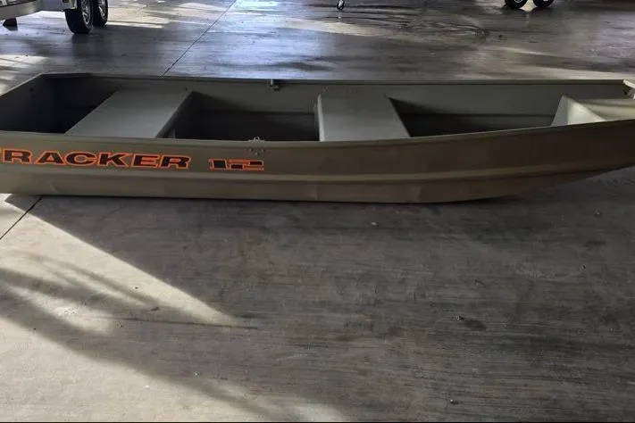 The Image of 2026 Tracker Grizzly 12 Jon boat on concrete floor, side view. - 0