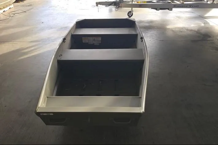 Slide: The Image of 2026 Tracker Grizzly 12 Jon boat in a garage, viewed from the rear. - 2