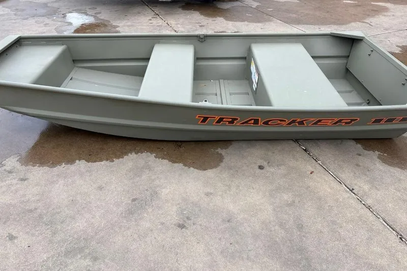 Slide: The Image of 2026 Tracker Grizzly 10 Jon boat on wet concrete surface. - 1