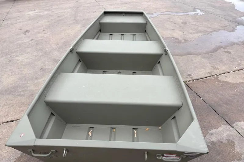 Slide: The Image of 2026 Tracker Grizzly 10 Jon boat on concrete surface, showcasing interior seating. - 2