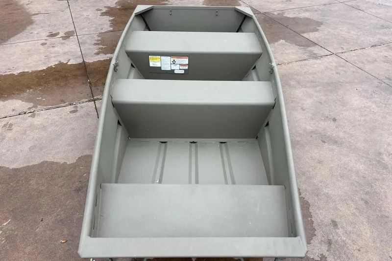Slide: The Image of 2026 Tracker Grizzly 10 Jon boat on concrete surface, showcasing interior seating and design. - 3