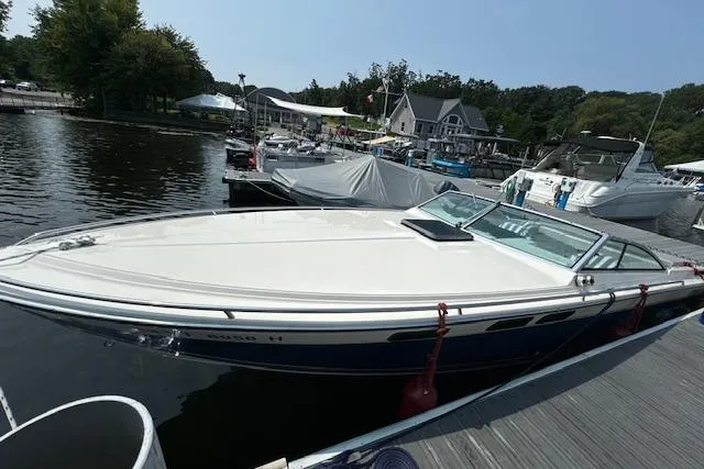 Slide: The Image of 1984 Formula 272 boat docked at a marina, surrounded by other boats and waterfront houses. - 11