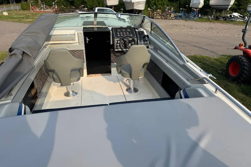 Slide: The Image of 1984 Formula 272 boat interior with dual seats and control panel, parked outdoors. - 3