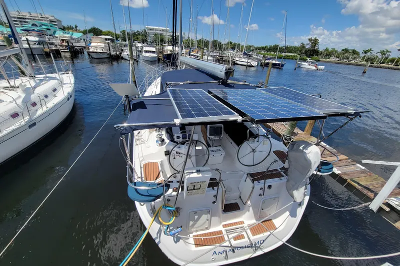 Slide: The Image of 2009 Hunter 49 sailboat with solar panels docked at a marina. - 14