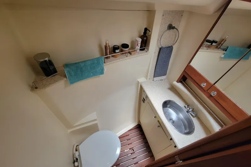 Slide: The Image of Compact bathroom in 2009 Hunter 49 yacht with sink, toilet, and toiletries. - 9