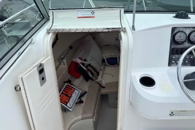 Slide: The Image of 2006 Boston Whaler 205 Conquest cabin interior with seating and storage. - 12