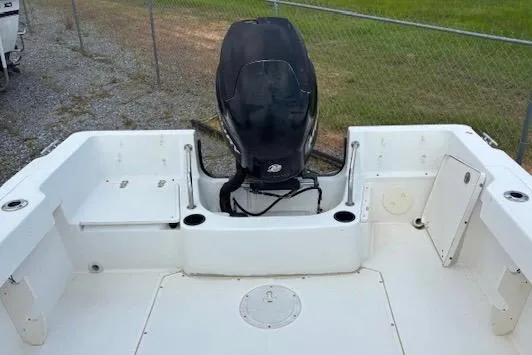 Slide: The Image of 2006 Boston Whaler 205 Conquest boat deck with outboard motor, docked on gravel. - 15