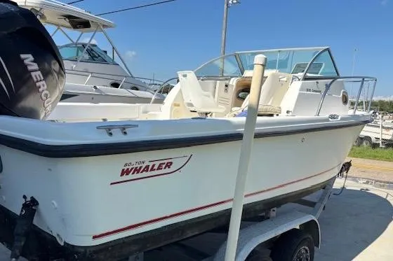 Slide: The Image of 2006 Boston Whaler 205 Conquest boat on trailer, docked outdoors. - 3