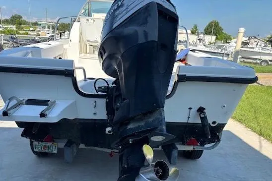 Slide: The Image of 2006 Boston Whaler 205 Conquest boat with outboard motor, docked on concrete. - 4