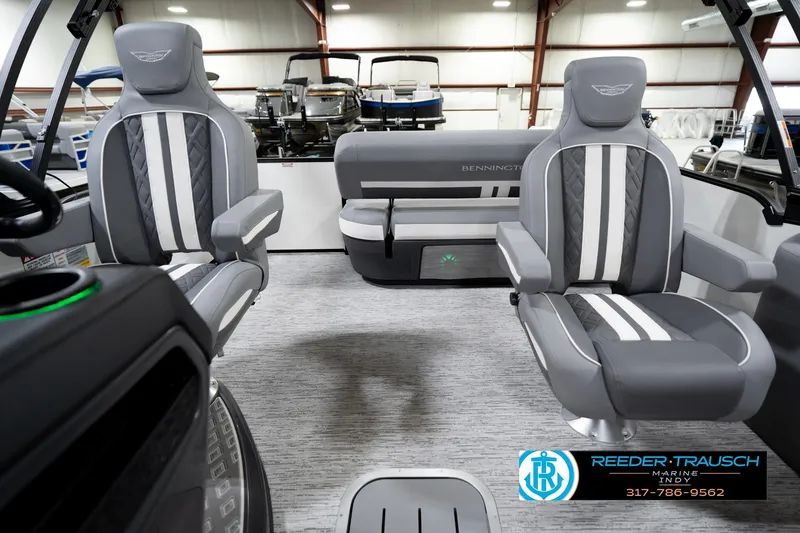 Slide: The Image of 2026 Bennington 22 MSB boat interior with gray and white seating in a showroom. - 16