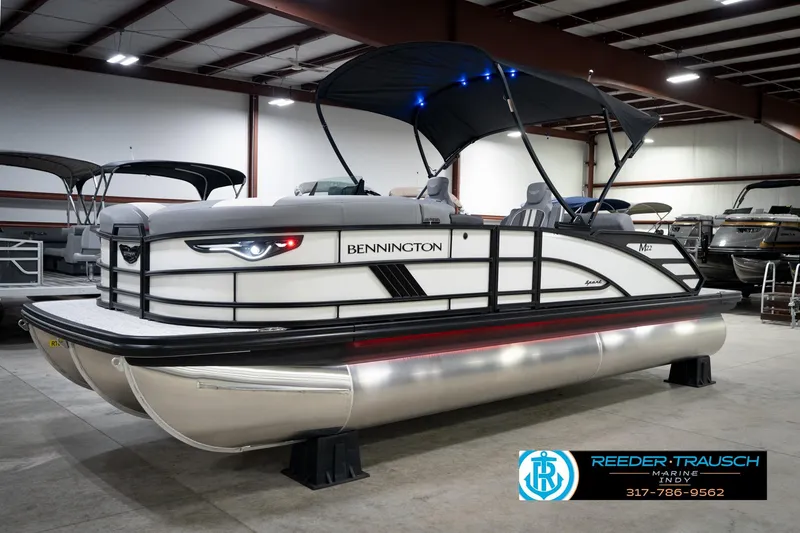 Slide: The Image of 2026 Bennington 22 MSB pontoon boat in showroom with canopy and sleek design. - 3