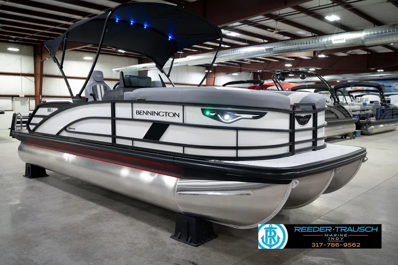 Slide: The Image of 2026 Bennington 22 MSB pontoon boat in showroom with canopy and sleek design. - 5
