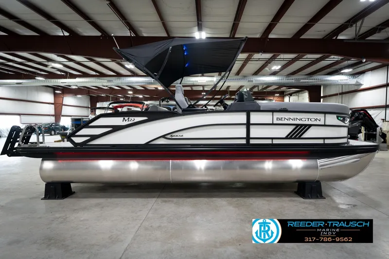 Slide: The Image of 2026 Bennington 22 MSB pontoon boat in a spacious indoor showroom. - 6