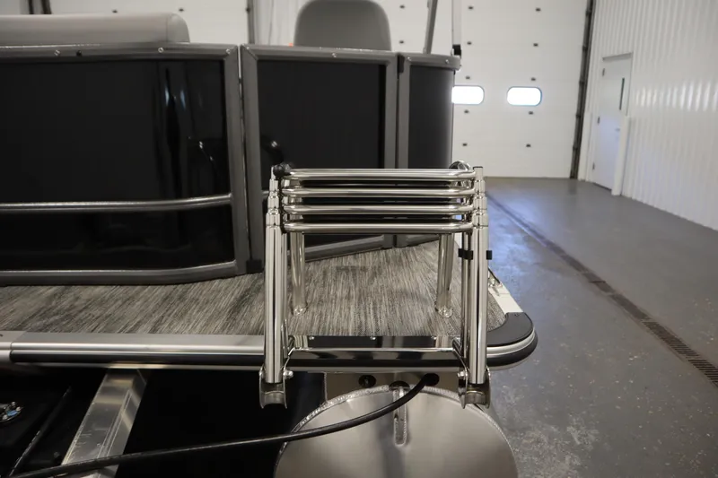 Slide: The Image of 2026 Bentley Pontoons LE 180 CR with stainless steel ladder in a garage setting. - 29