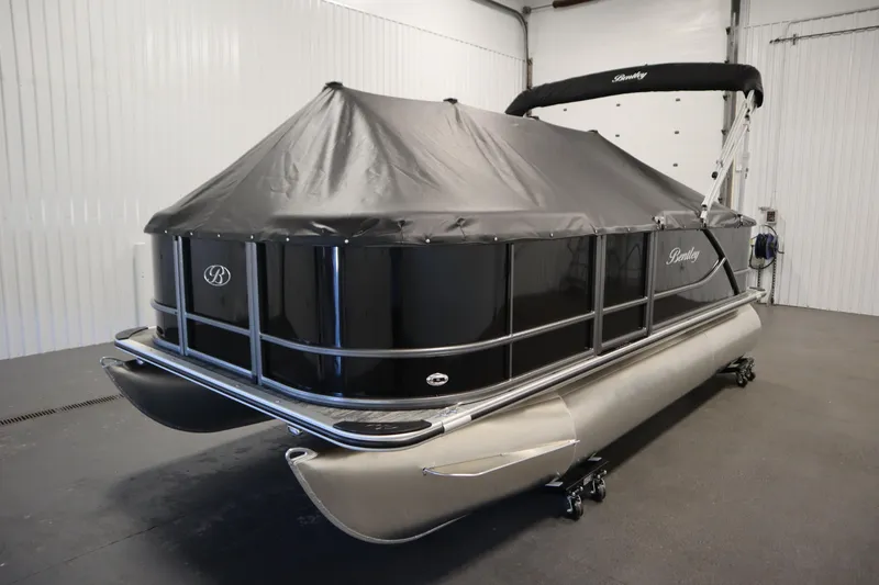 Slide: The Image of 2026 Bentley Pontoons LE 180 CR, black pontoon boat with cover, in indoor storage. - 30